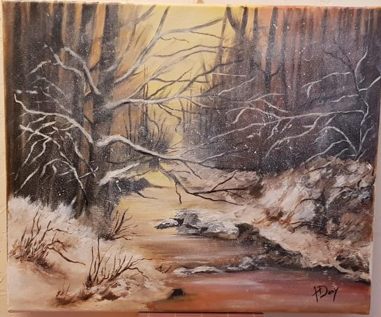 Un ruisseau à travers une forêt enneigée, illuminé par une lumière dorée.